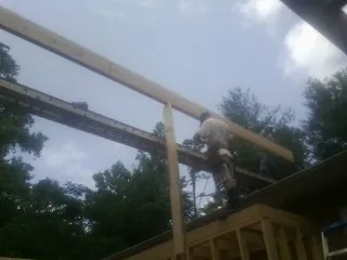 Carpenter setting a ridge beam over a new addition frame — Ice Dam Removal by Roofing Brothers in Centerbrook
