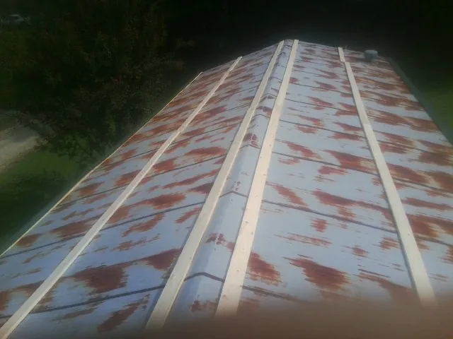 Rusted metal roof panels with new wood purlins before replacement — Storm Damage Roof Repair in Centerbrook by Roofing Brothers
