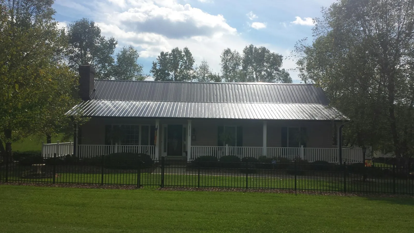 Gray metal roof on a brick ranch with a full width front porch — Gutter Guard Installation work by our crew in Centerbrook