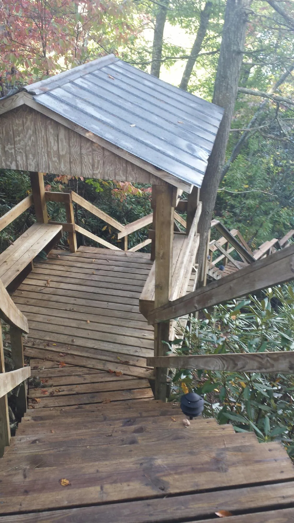 Metal roofed shelter over wooden steps on a wooded walkway — Skylight Repair & Installation work by our crew in Centerbrook